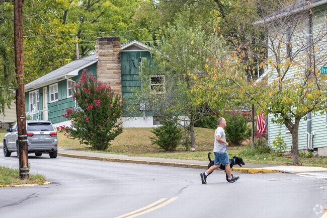 A Jerome Park man and his dog are in step as they cross a neighborhood street.