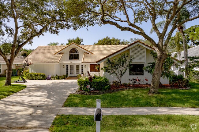 Spanish style home surrounded by lush landscaping in the Maplewood neighborhood.