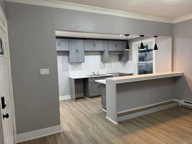 Open Concept Kitchen & Dining Area- Modern open kitchen with bar seating, ideal for entertaining.