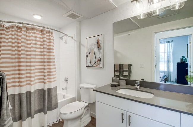 Bathrooms with white cabinetry, grey quartz countertops, and luxury vinyl plank flooring