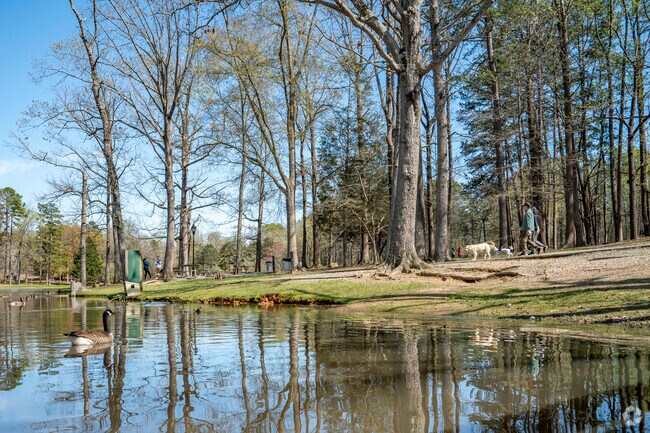 There is a paved path surrounding the duck pond of Park Road Park.