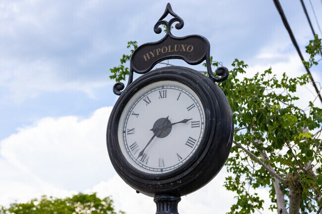There is a large old school clock hanging by the Town House entrance in Hypoluxo neighborhood.