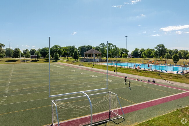 Residents and friends use the football field near the pool at Hunting Park in Philadelphia.
