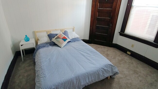 Bedroom with double bed and small closet.