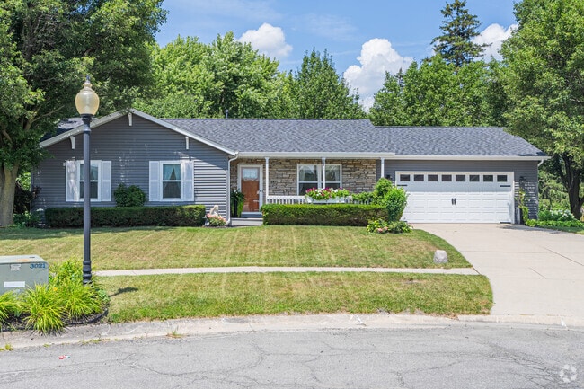 A gray ranch-style home features stone accents and white shutters in South Haven.