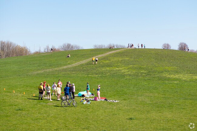 Friends gather at the base of Cricket hill as others trek upwards in the distance.