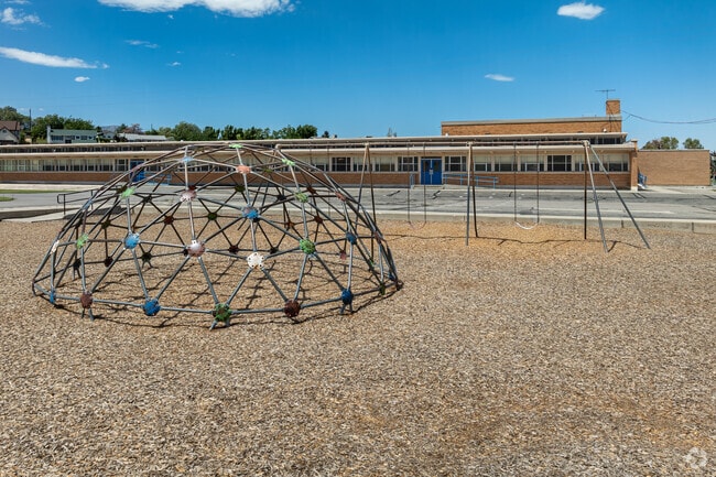 A climbing dome and swing set are located behind Western Hills Elementary.