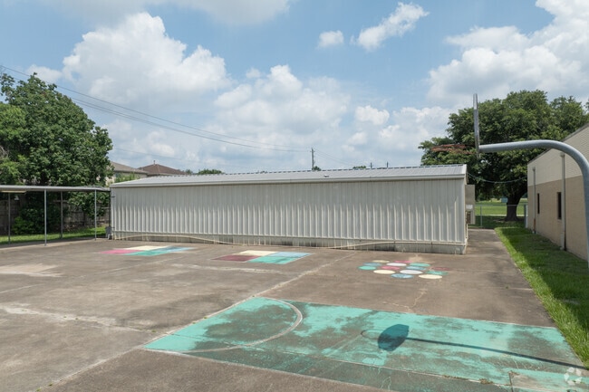 Students enjoy a colorful playground and a basketball court for recreation.