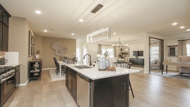 Elegant marble island and sophisticated lighting define this open-concept kitchen at Colony at Pinehurst.
