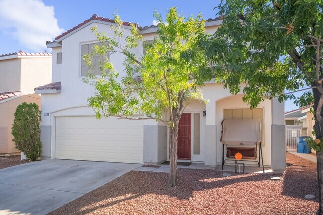Mediterranean / spanish home with a tile roof, a garage, driveway, and stucco siding