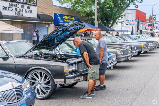 Car lovers look under the hood of a car at the Berwyn Rt 66 Car Show.