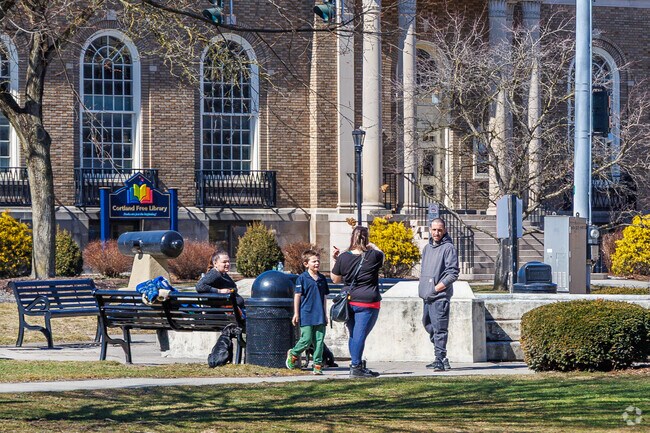 Some residents walk along the paved paths that border Courthouse Park, the grassy space in front of the historic courthouse with statues honoring heroes who fought for the Union during the Civil War and victims of the 9/11 tragedy.
