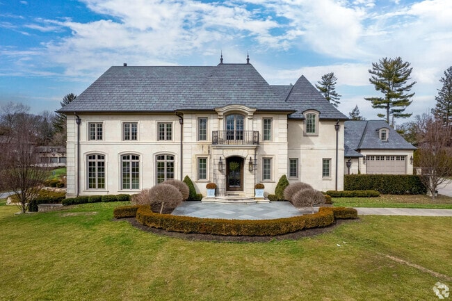 A French Revival home in Upper Arlington features a well-landscaped front yard.