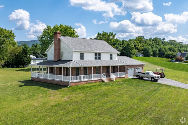 A stunning farmhouse with wrap around porch, overlooking a huge yard in Mount Aetna.