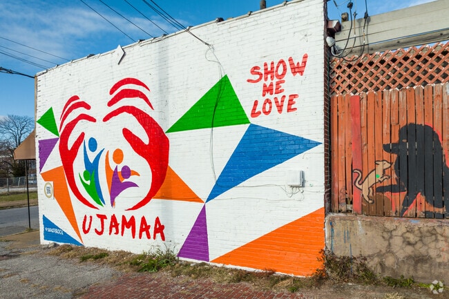 Painted murals with positive messages line the sidewalk in Wells/Goodfellow.