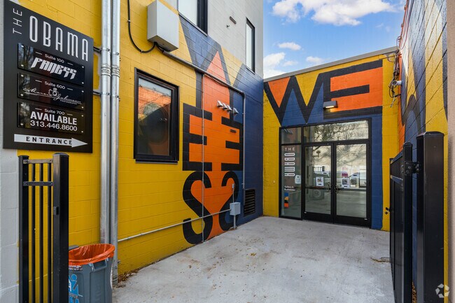 Neighbors get inspired by the Yes We Can Mural at the Obama Building in the Holcomb Community.