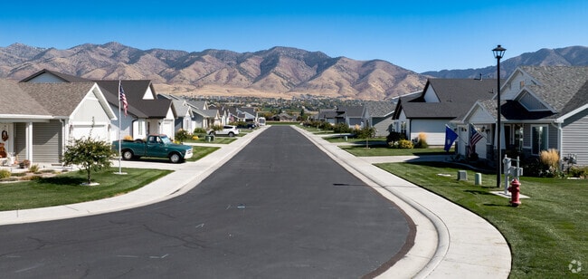Quiet neighborhood street in Hyde Park, Utah, featuring modern homes and the stunning backdrop of the Cache Valley mountains.