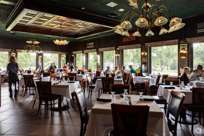 Interiors of Ki's Steak & Seafood with large windows open to the garden and small farm.