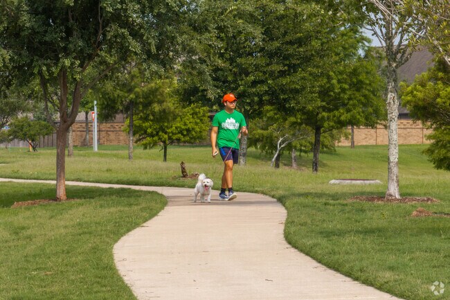 A man walks his dog along a quiet sidewalk in central Shadow Creek Ranch.