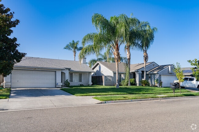 Two Spanish style inspired homes with large palm trees in this neighborhood of Farmersville.