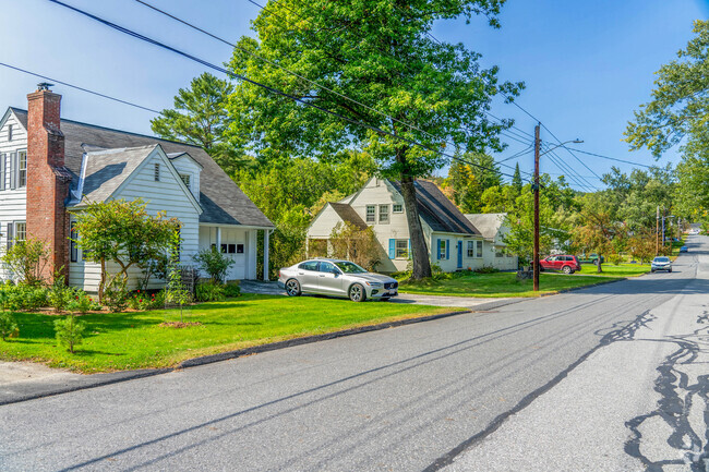 A row of homes in Park West are shaded by a large maple tree.