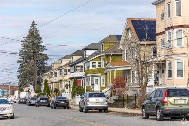 A row of colorful, traditional multi-family homes is common all around Lawrence, MA.