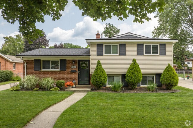 Raised brick ranch home with shuttered window adorns the street in SMB Estates.