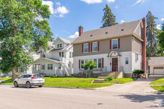 A two-story beige and white house with red accents in the Kutzky Park neighborhood.