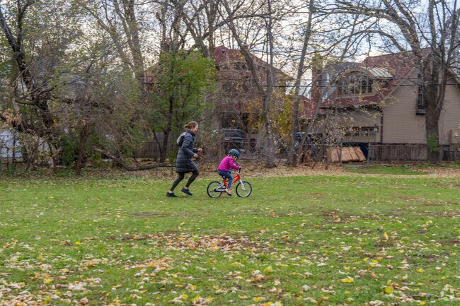 A parent teaching their kid how to bicycle at Kojetin Park in Morningside.