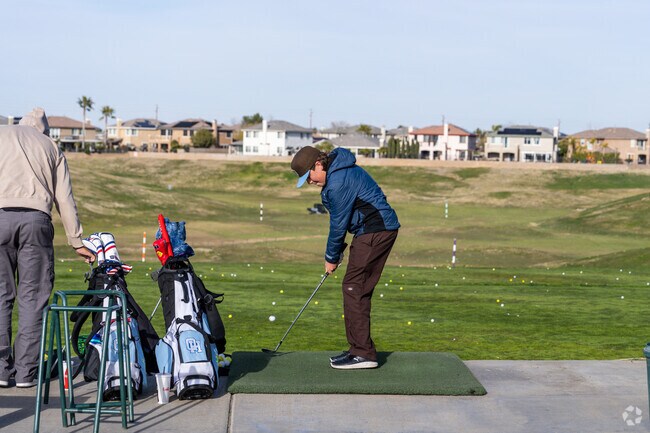 A young man hits a ball at the driving range at the Rancho Vista Golf Course in West Palmdale.