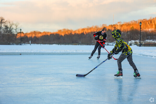 Families enjoy shooting the puck around the ice into the evening at Mill Park in Augusta.