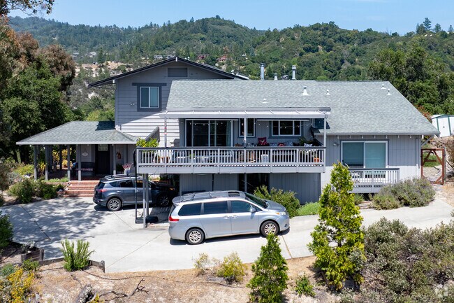 This split-level Traditional-style home in Ben Lomond features a spacious front deck, covered carport, and hillside views, blending suburban comfort with mountain tranquility.