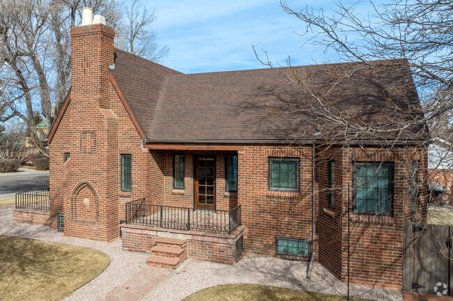 This charming brick home in Casper showcases classic Tudor Revival architecture with intricate brickwork and steep gabled roofs