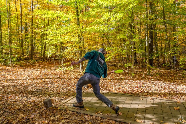 A person throws their disc at the Quarries Disc Golf course in Websterville.