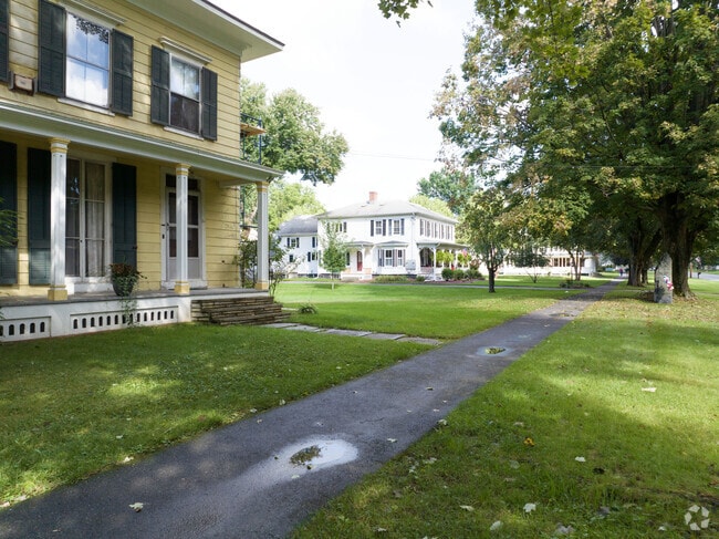A gabled historic home as other homes line Elm Street in Hatfield, mA.