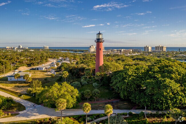 The historic Jupiter Lighthouse towers over lush greenery near the Loxahatchee River.
