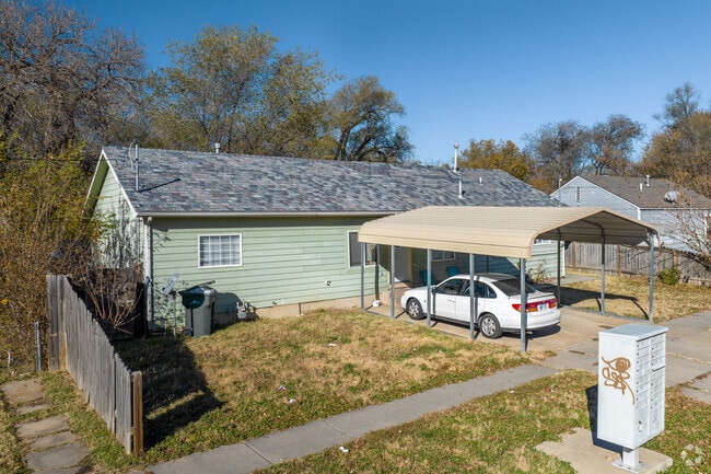 This Hilltop home has a covering for cars in the driveway.