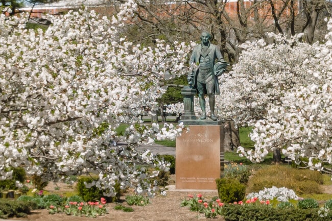 A George Washington Statue can be found amongst blooming trees in Flushing.