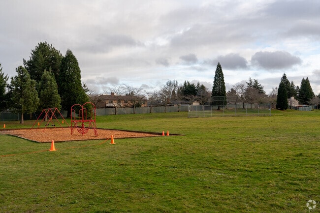 A playground and large sports field sit behind campus.