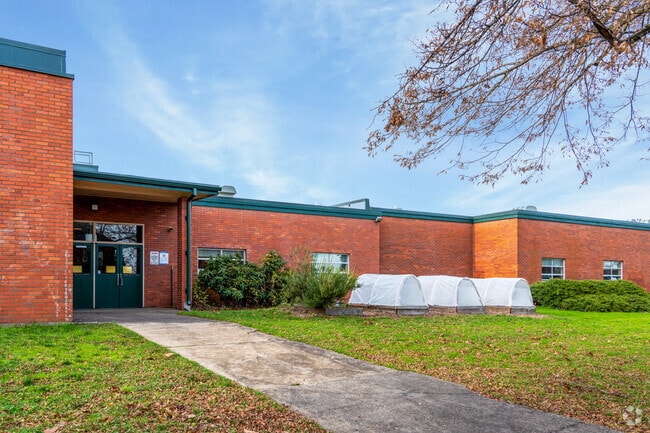 There is a student green house on the side of the school.