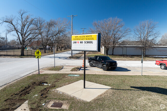 There is a sign for White Elementary School near the main road.