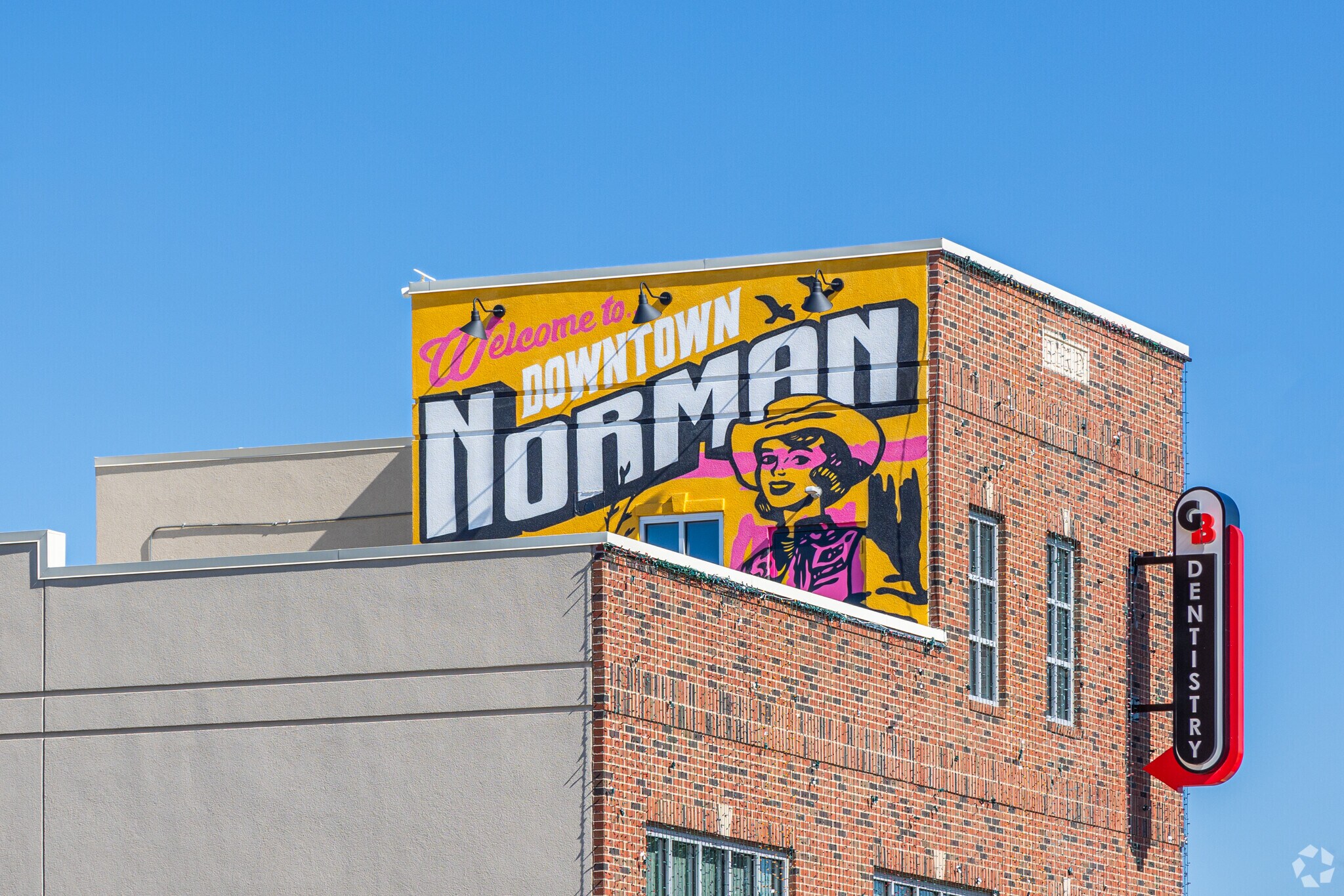 Admire the vibrant 'Welcome to Downtown Norman' wall art.
