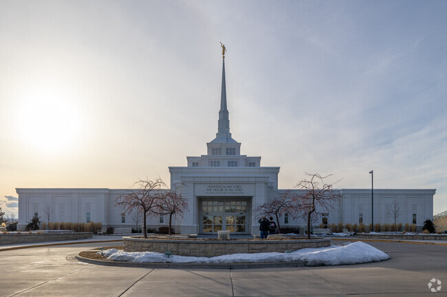 Two people capture the beauty of the Billings Montana Temple near West Shiloh with their cameras.