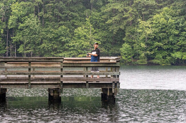 Experienced anglers fish through a rainstorm at Sandy Bottom Nature Park in Saunders.