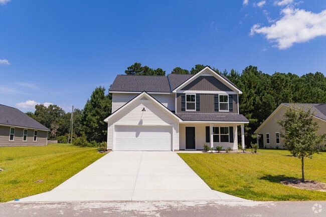 Beautiful two-story new construction home framed by lush trees in Seabrook.