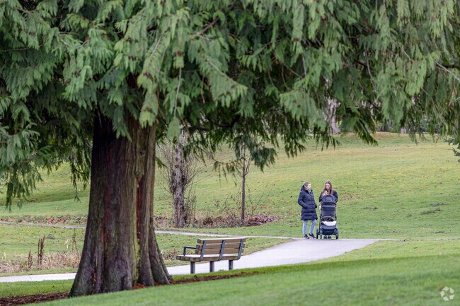 Two pedestrians walk a baby through Franklin Park.