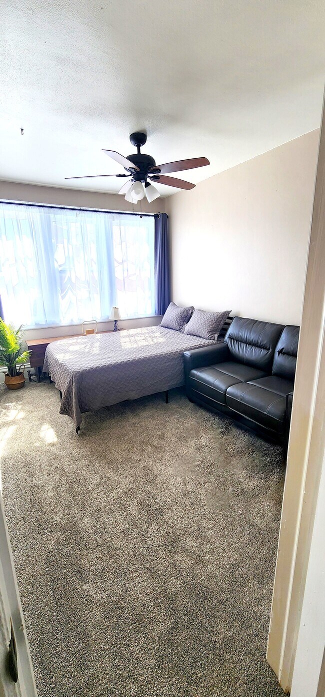 Primary Bedroom with Plush Queen Bed & Loveseat Bright and Inviting with Blackout Curtains