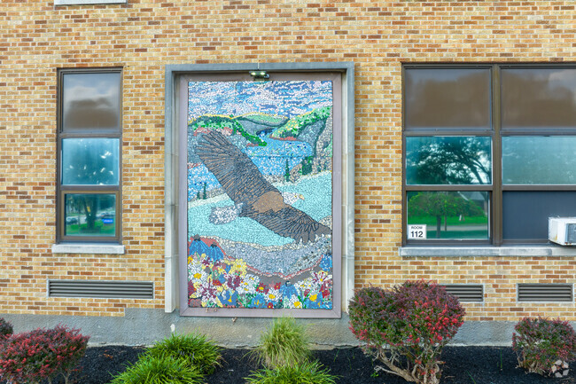 Mosaic tile artwork on outside of school showcases the school mascot.