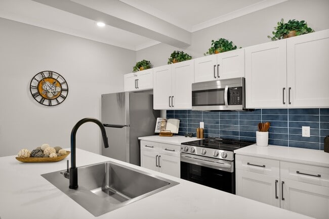 Modern kitchen with sleek stainless steel appliances, elegant white cabinetry, and a stylish island for casual dining.
