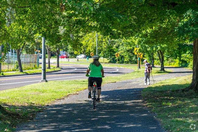 Locals bike around the Paschall neighborhood on the Cobbs Creek Trail surrounding the park.
